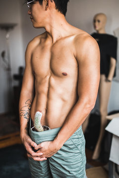 Well built handsome man topless with a cactus in his pants