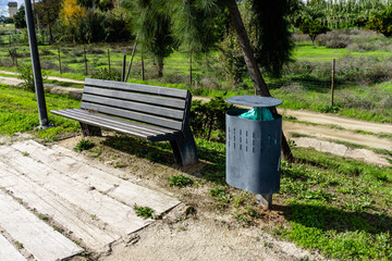 Street bench next to the modern garbage bin.