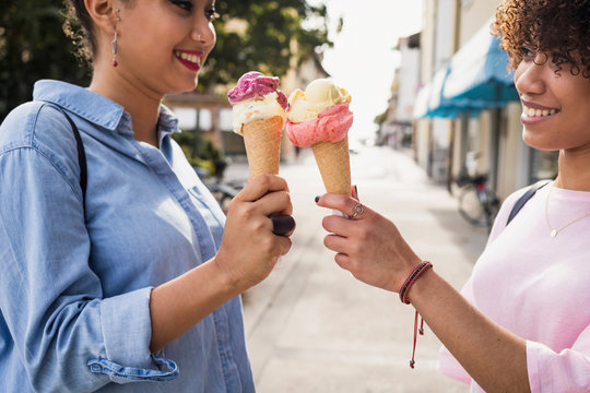 Two female friends eating ice cream outdoor
