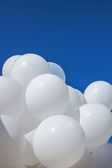 White balloons against the blue sky