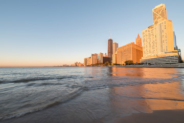 Reflection of Chicago skyscraper on Michigan lake at sunrise