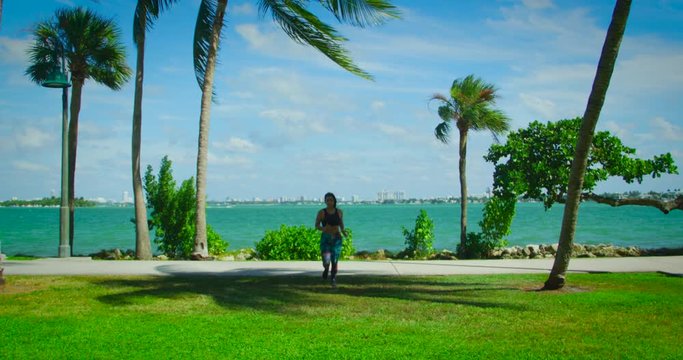 YOUNG FIT GIRL RUNNIN AND  WORKING OUT IN FRONT OF THE OCEAN