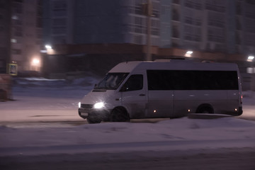 Fototapeta premium minibus is moving in the winter at night in the city