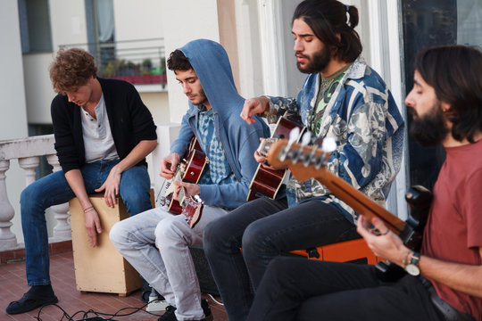 young people playing music together on a terrrace on a rooftop a