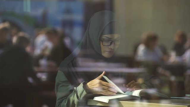 Muslim woman in eyeglasses studying, student exchange program, European college