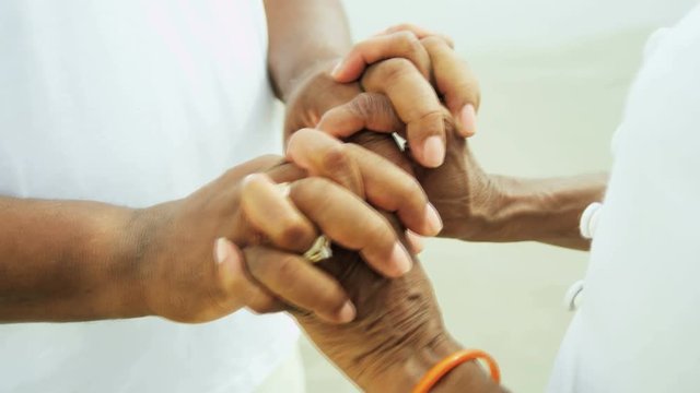 An Elderly African American couple holding hands outdoors on the beach enjoying gentle relaxation 