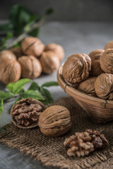 Walnuts in wooden bowl. Whole walnut on table