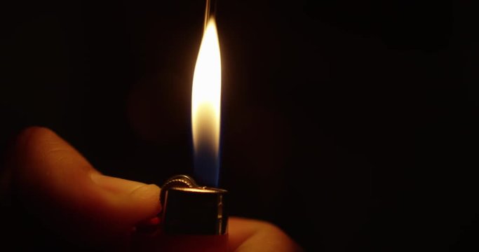 CLOSEUP IN SLOW MOTION OF A LIGHTER SPARK WITH A BLACK BACKGROUND