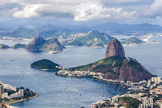 Views from Christ The Redeem mountain over Sugar Loaf, Rio do Janeiro city, suburbs and favelas, amazing views over the bays, islands, beach and the city skyline from the top on a cloudy day, Brazil
