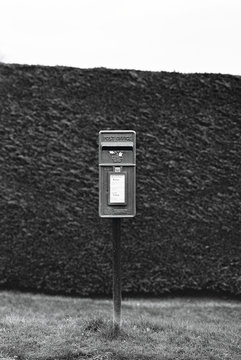 British post box against a hedgerow shot on black and white film.