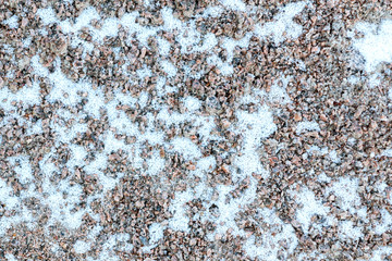 First light snow at the beginning of winter on surface of a gravel path. Symbol of the coming...