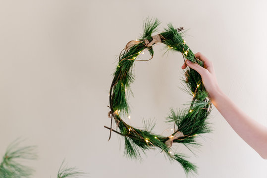 hand holding a DIY  holiday/Christmas wreath 