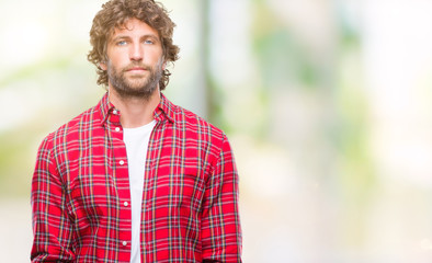 Handsome hispanic model man over isolated background with serious expression on face. Simple and natural looking at the camera.