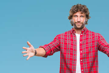 Handsome hispanic model man over isolated background looking at the camera smiling with open arms for hug. Cheerful expression embracing happiness.