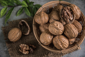 Walnuts in wooden bowl. Whole walnut on table