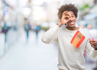 Afro american man flag of Spain over isolated background with happy face smiling doing ok sign with hand on eye looking through fingers