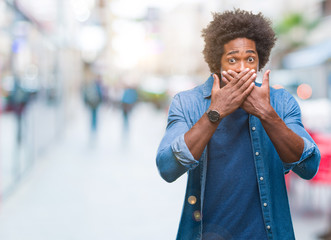 Afro american man over isolated background shocked covering mouth with hands for mistake. Secret concept.