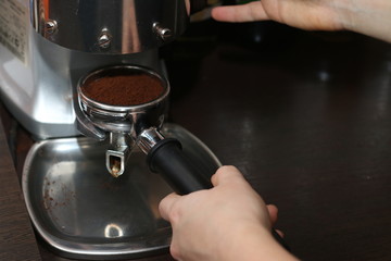 professional espresso machine at coffee shop. barista hold coffee cone