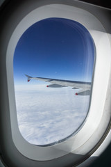 Looking through the window while flying above a sea of clouds