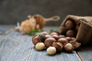 Organic Macadamia nut on wooden table - vintage filter.