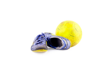 old  football shoes damaged and old  dirty yellow futsal ball on white background football  object...