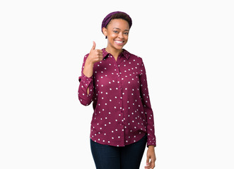 Beautiful young african american woman wearing head scarf over isolated background doing happy thumbs up gesture with hand. Approving expression looking at the camera showing success.