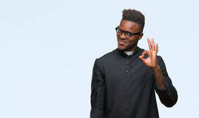 Young african american priest man over isolated background smiling positive doing ok sign with hand...