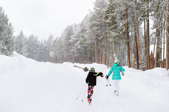 Two children setting out for a snow day skiing