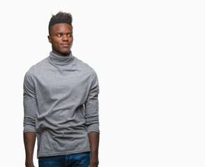 Fototapeta premium Young african american man over isolated background smiling looking side and staring away thinking.