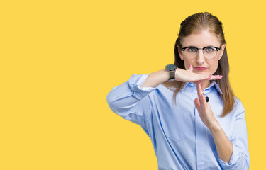 Beautiful middle age mature business woman wearing glasses over isolated background Doing time out gesture with hands, frustrated and serious face