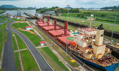 Large cargo ships pass through the Panama Canal locks.  This everyday event, provides income from both fees and tourism for the whole country. - 236534494