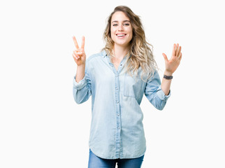 Beautiful young blonde woman over isolated background showing and pointing up with fingers number seven while smiling confident and happy.