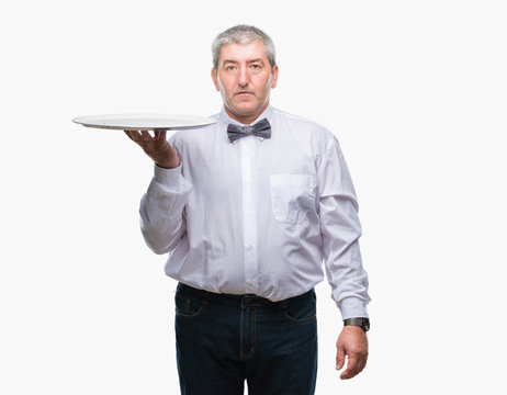 Handsome Senior Waiter Man Holding Silver Tray Over Isolated Background With A Confident Expression On Smart Face Thinking Serious