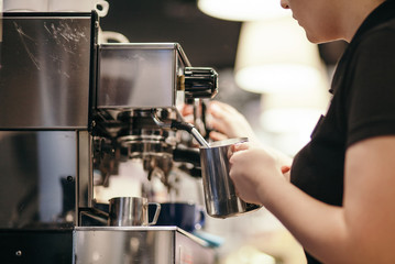 Crop person brewing coffee with machine

