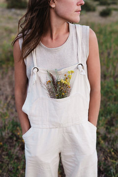 woman with wildflowers in her overalls 
