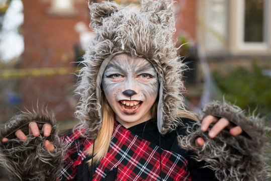 Girl dressed as a bear for Halloween makes a growling gesture