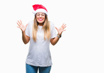 Obraz na płótnie Canvas Young beautiful woman wearing christmas hat over isolated background celebrating mad and crazy for success with arms raised and closed eyes screaming excited. Winner concept