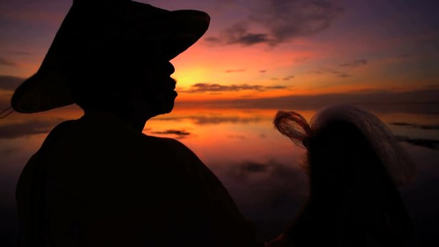 Balinese fisherman throwing traditional net into the Indian ocean at sunset