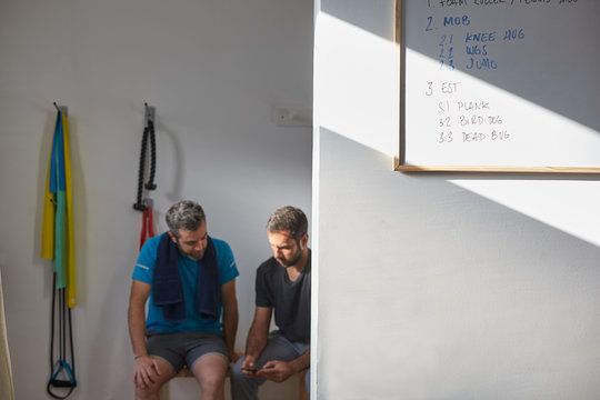Sports coach giving instructions to a male pacient for the exercises plan
