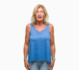 Fototapeta premium Middle age blonde woman over isolated background afraid and shocked with surprise expression, fear and excited face.