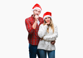 Young couple in love wearing christmas hat over isolated background with hand on chin thinking about question, pensive expression. Smiling with thoughtful face. Doubt concept.