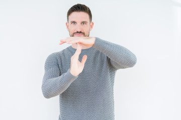 Young handsome man wearing casual sweater over isolated background Doing time out gesture with...