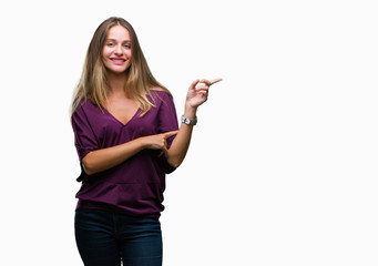 Young beautiful blonde elegant woman over isolated background with a big smile on face, pointing with hand and finger to the side looking at the camera.