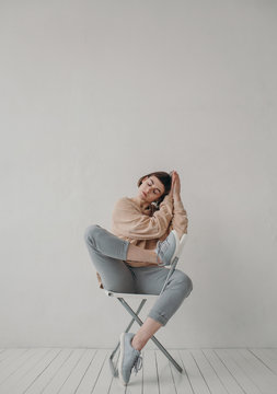 Bautiful caucasian brunette woman posing on the chair
