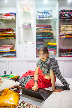 A Businesswoman using laptop for her small business of selling traditional Indian Clothes