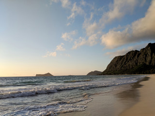 Fototapeta na wymiar Gentle wave lap on Waimanalo Beach looking towards Rabbit island and Rock island