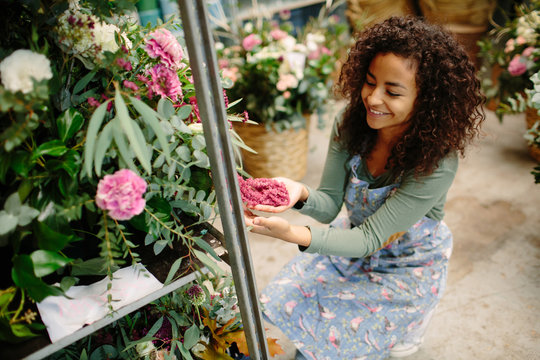 Content woman exploring freshly delivered flowers