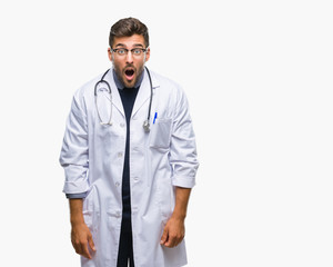 Young handsome doctor man over isolated background afraid and shocked with surprise expression,...