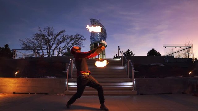 Public fire performance with man spinning poi