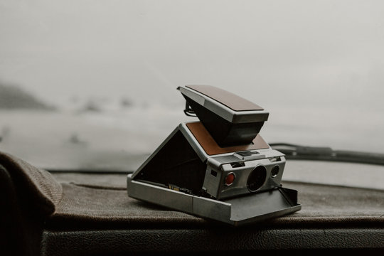 vintage film camera on dashboard of car on overcast day